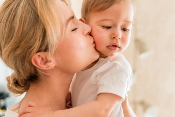 Mother kissing her baby and feeling grateful for having AB-KOLICARE probiotics